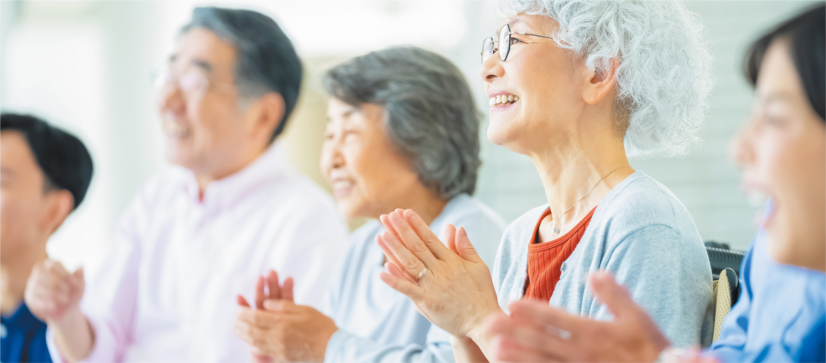 笑顔で手拍子をしながら楽しむ5人の男女